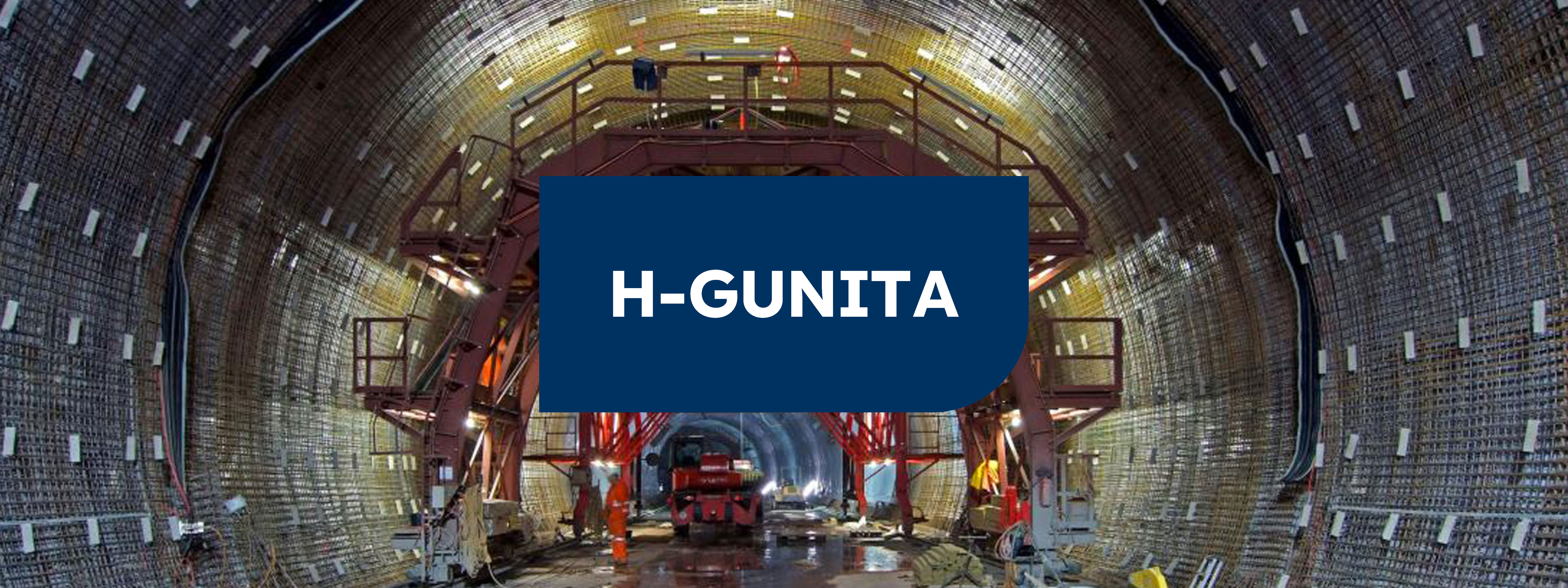 Interior de un tunel forrado de hormigón con maquinaria y un cartel en el centro verde con las letras "H-GUNITA" en blanco.