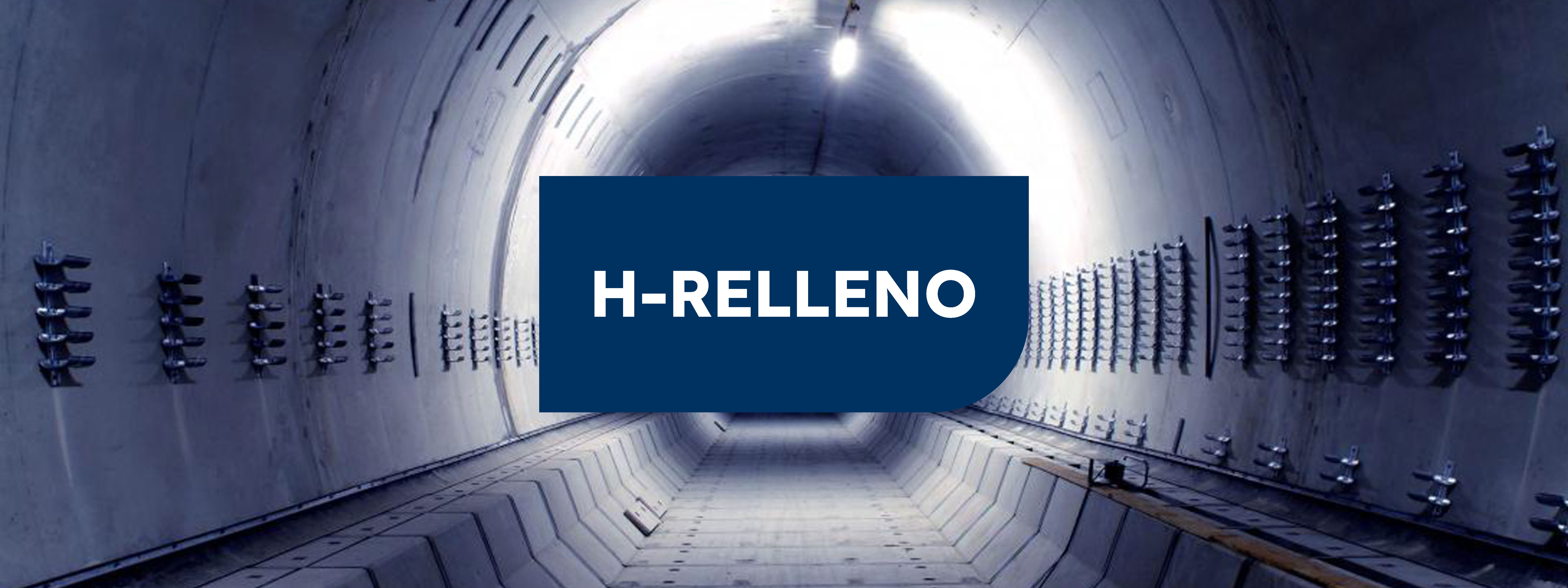 Interior de tunel de hormigón con luz al fondo y cartel verde en el centro con las letras H-RELLENO" en blanco.