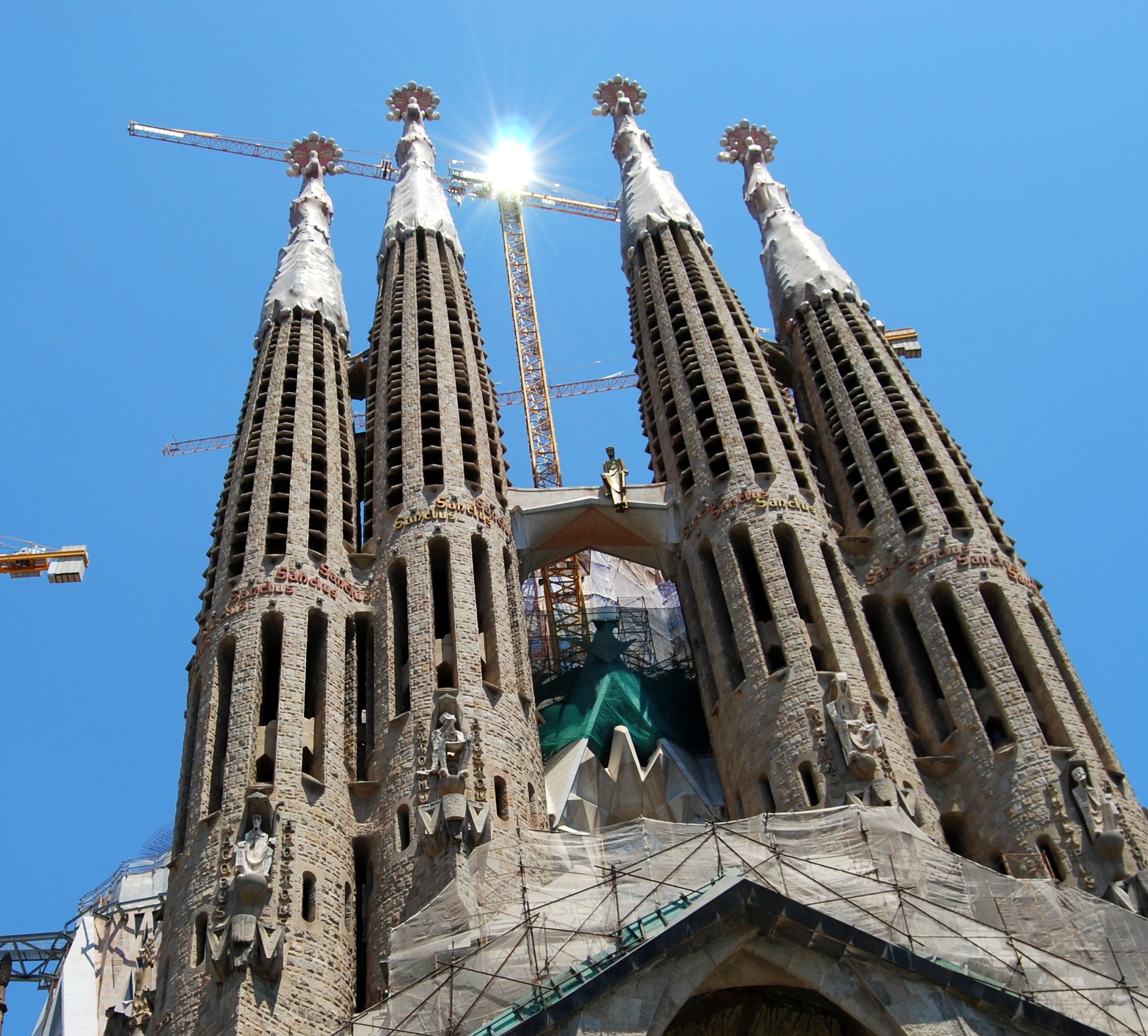 Portada de la Sagrada Familia de Barcelona con grua de construcción al fondo.