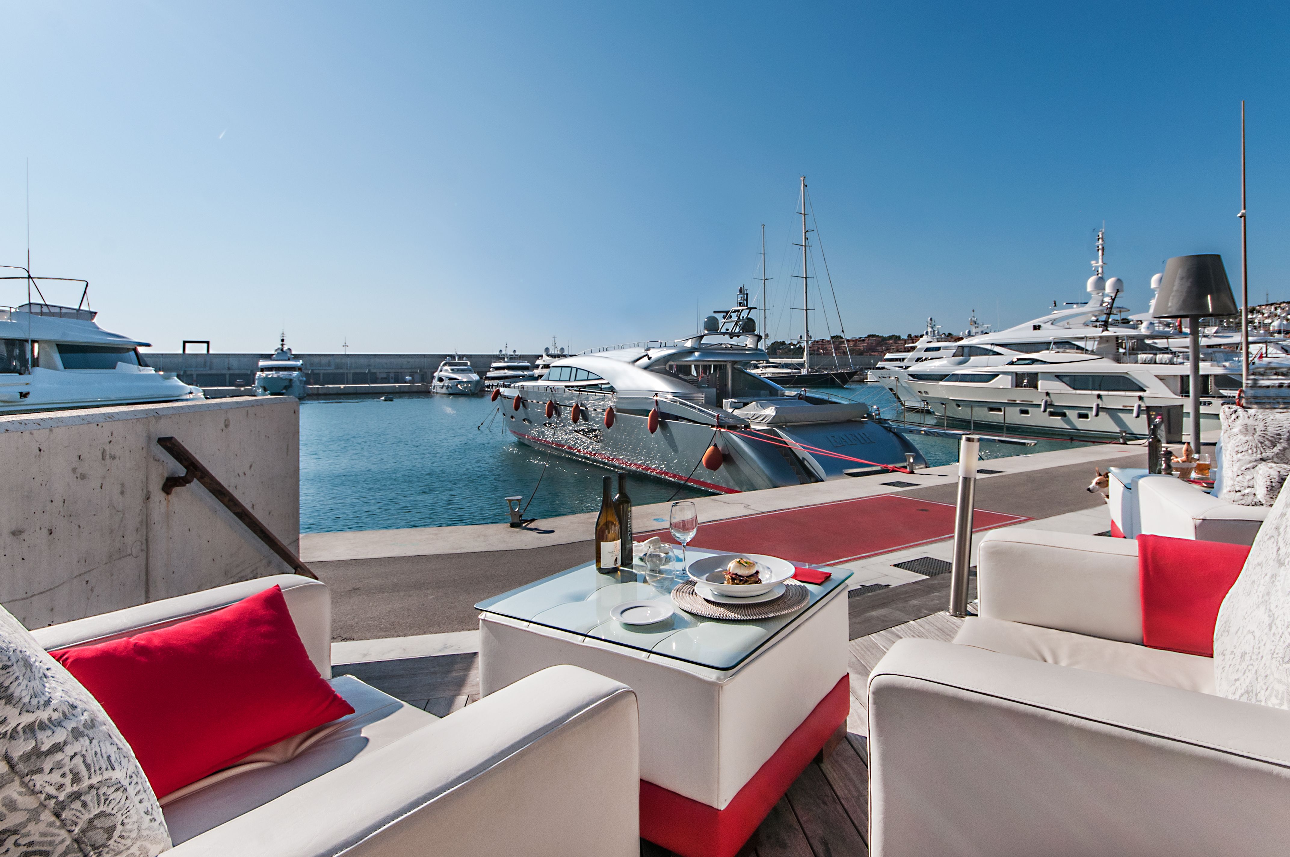 terraza de restaurante de lujo moderno junto a zona de amarre de yates en Port Adriano