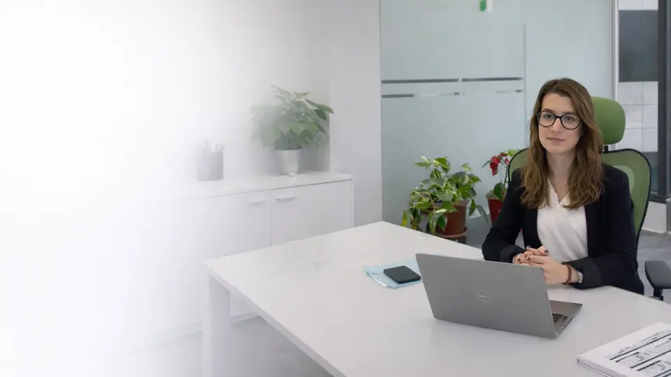 Oficina con computadora portátil y plantas.